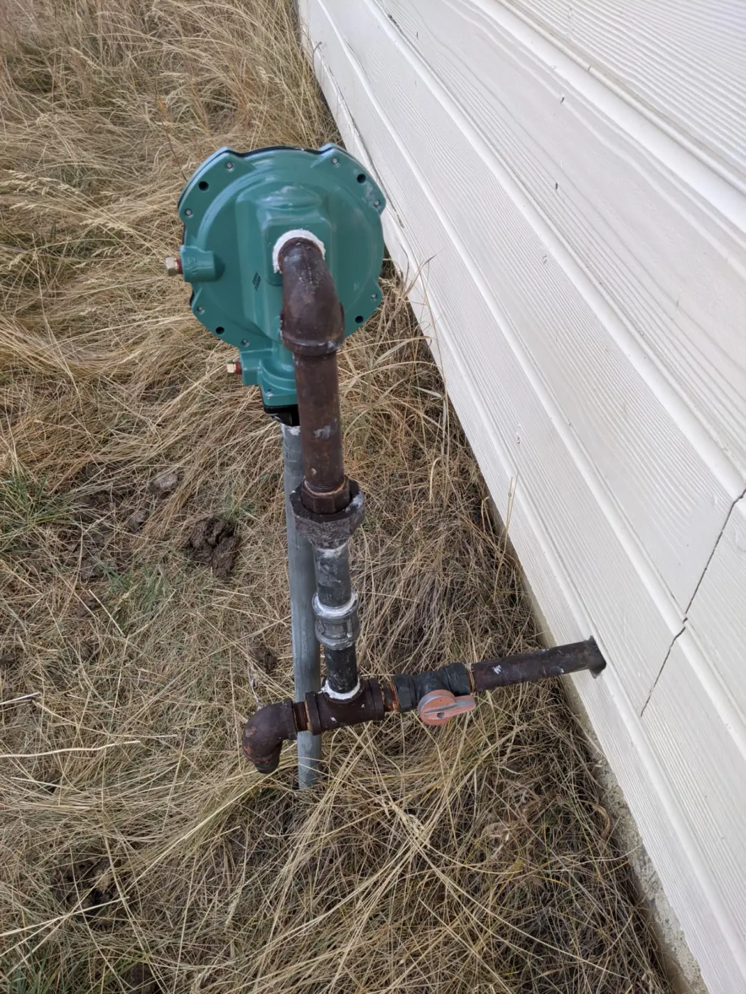 Exterior gas meter and gas piping installed beside a home