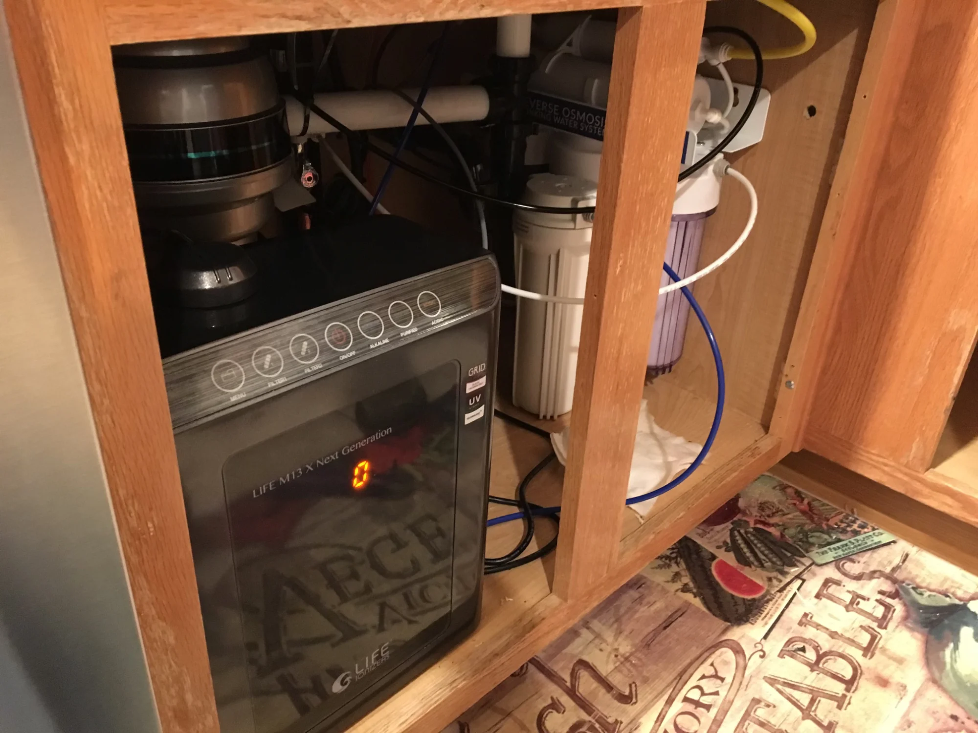 Utility sink installed below a dark backsplash with exposed plumbing below