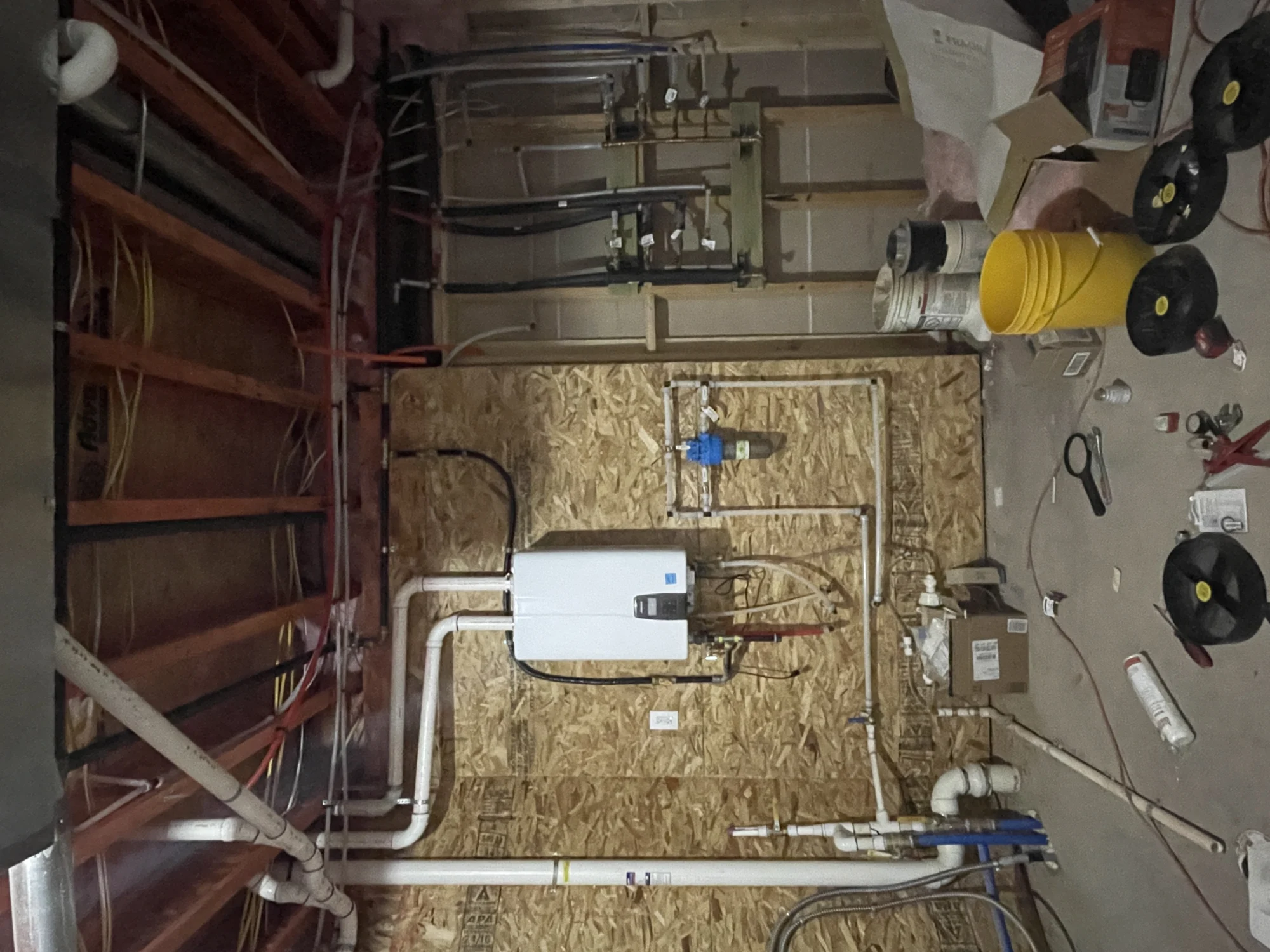 Rough plumbing and piping installed in an unfinished mechanical room