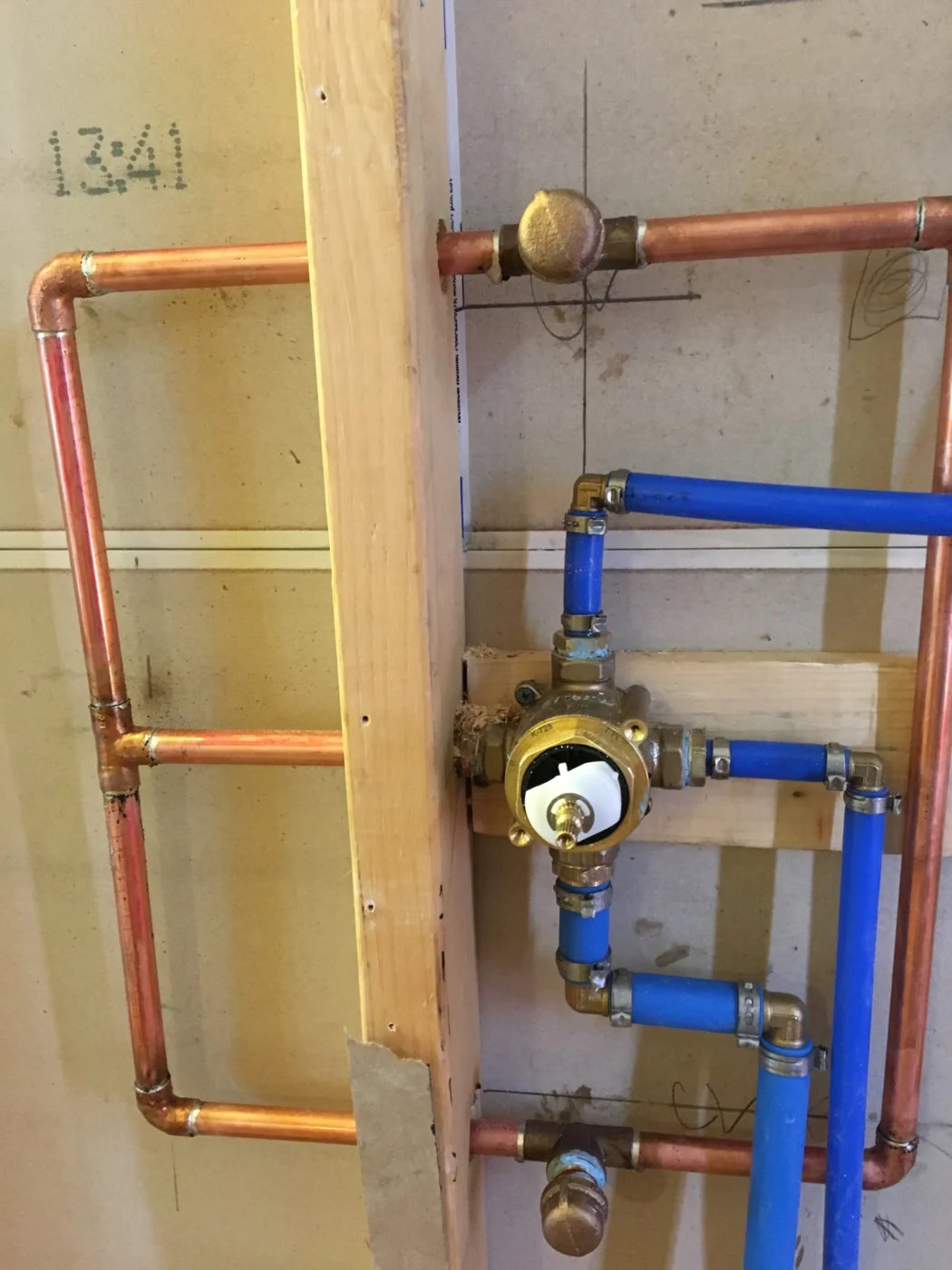 Residential water heater installed in a mechanical room with nearby plumbing connections