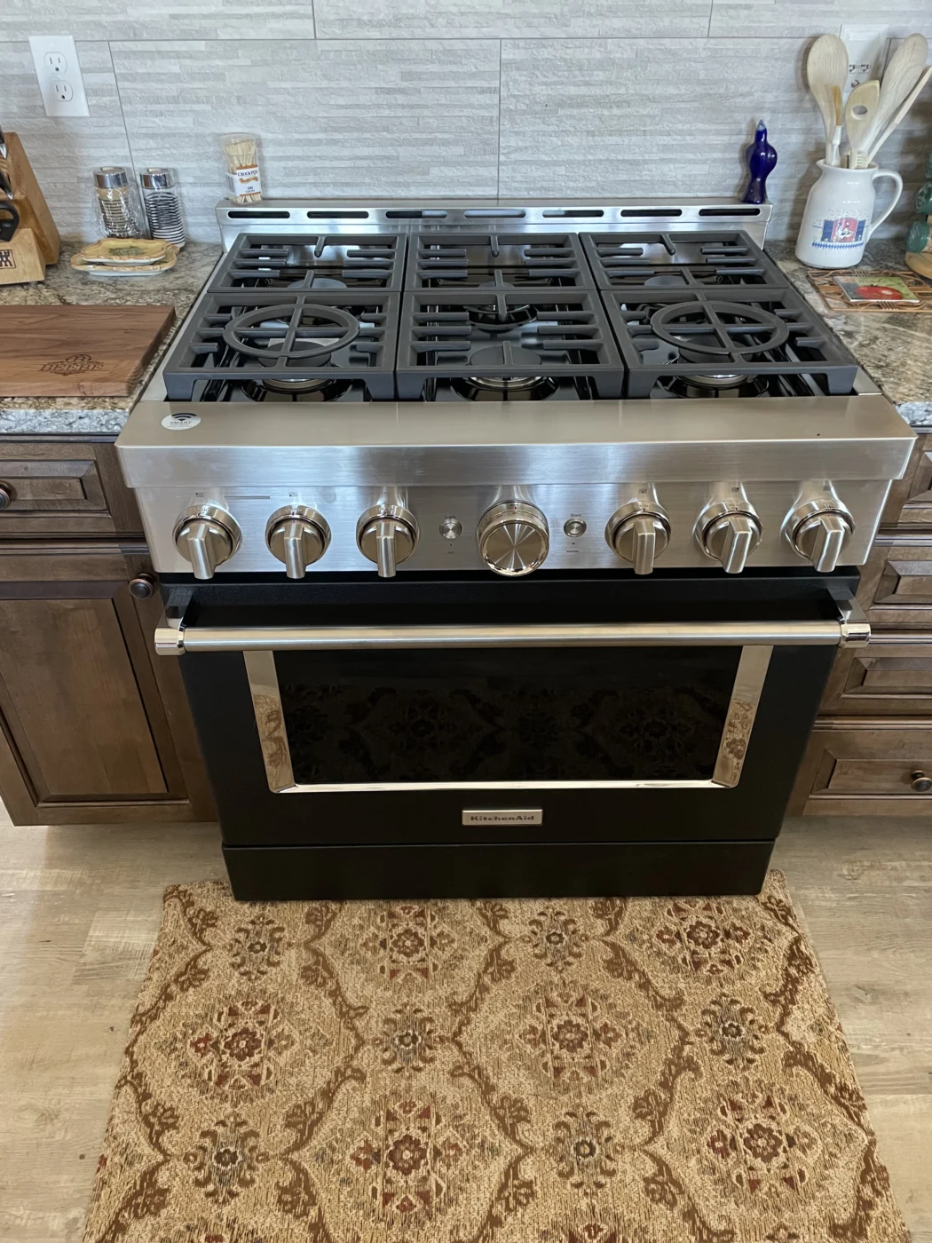 Kitchen gas range installed below a tiled backsplash